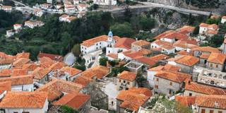 The traditional red-roofed houses of Dhërmi, nestled on the mountainside with panoramic views.