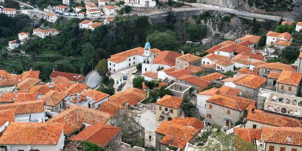 The traditional red-roofed houses of Dhërmi, nestled on the mountainside with panoramic views.