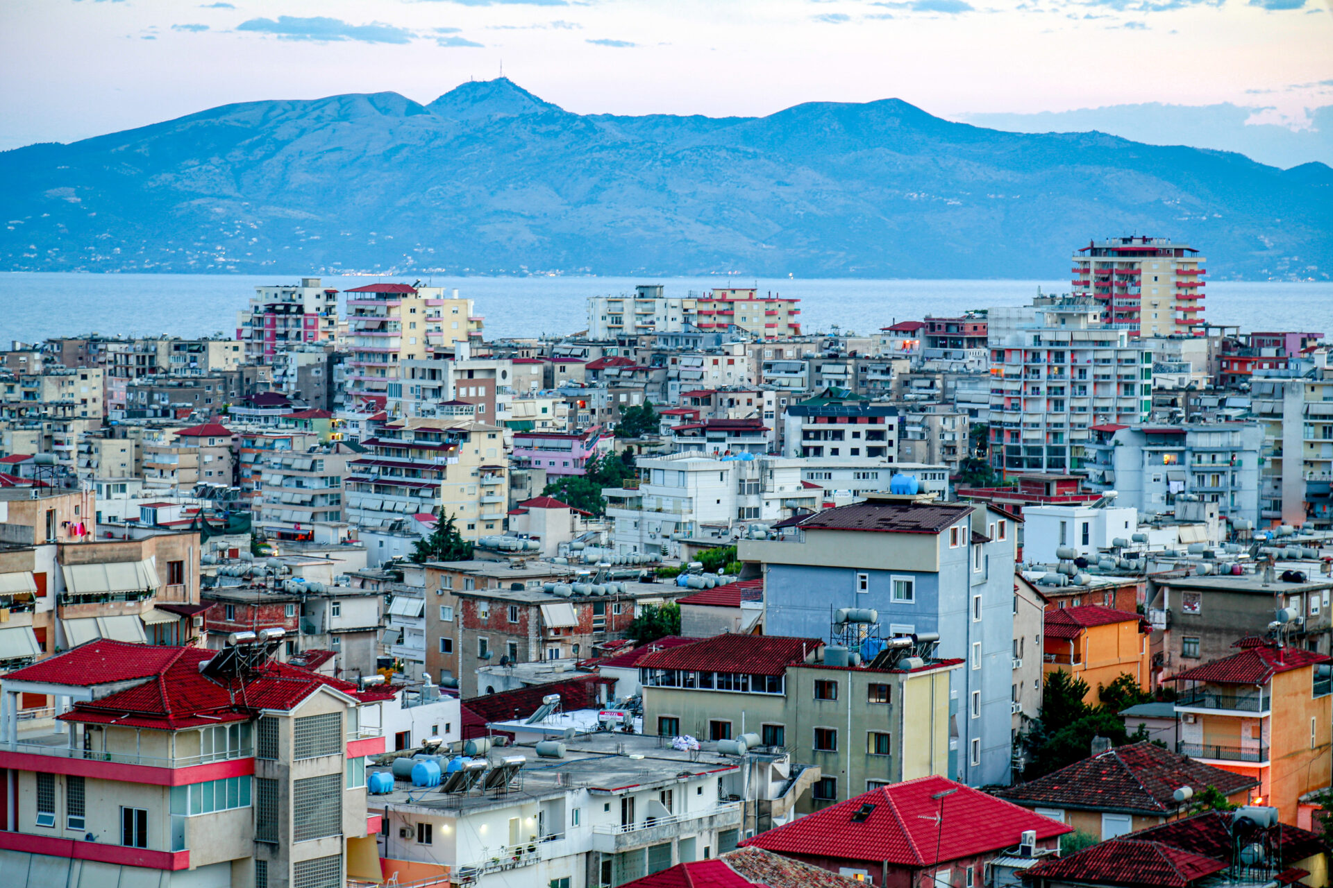 Cityscape of Saranda with sea and mountain views in the background.