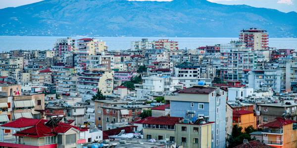 Cityscape of Saranda with sea and mountain views in the background.