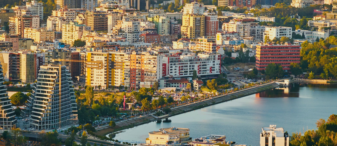 A view of Tirana with modern buildings and the city’s Artificial Lake.